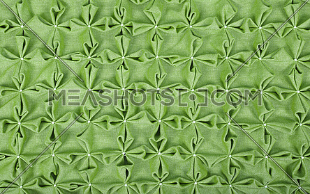 Close up background texture of green textile puffs for Canadian smocking upholstery decoration with beads