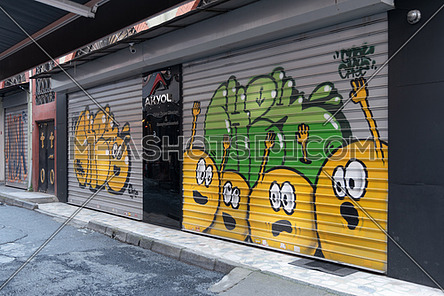 Istanbul, Turkey - April 18, 2017: Closed shop exterior with metal rolling doors painted with colorful graffiti at Hoca Tahsin Street, Karakoy district