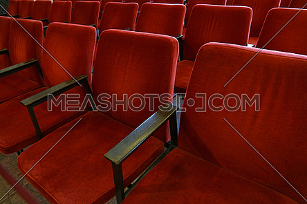Close up red soft chair seats in a row, personal perspective, high angle view