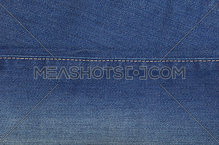 Dark indigo blue washed cotton jeans denim texture background with stitching seam edge line, close up