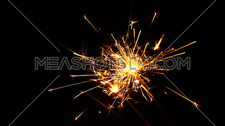 Close up group of several festive firework sparklers over black background, low angle side view, selective focus