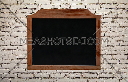 Close up old black school chalkboard blackboard sign in vintage brown wooden frame isolated on background of white brick wall