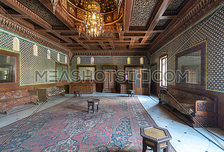 Manial Palace of Prince Mohammed Ali. Moroccan hall at the ceremonies building with blue Turkish floral pattern ceramic tiles, vintage furniture, and framed mirrors, Cairo, Egypt
