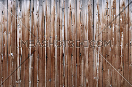 Close up background texture of old vintage brown weathered vertical knotted wooden plank fence or wall