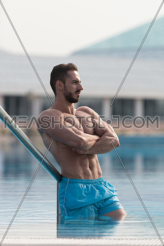 Man Resting Relaxed On Edge Of Swimming Pool-98796