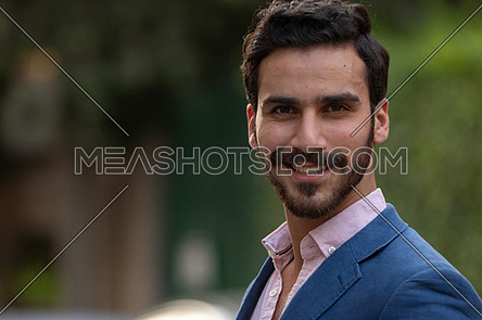 Mid-shot an elegant man walking in the the street in formal suit in blue at day