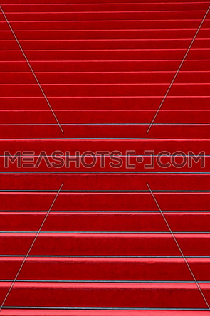 Close up red carpet covered stairs perspective ascending, low angle view