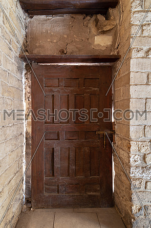 Facade of old abandoned stone bricks wall with grunge weathered wooden door, Old Cairo, Egypt