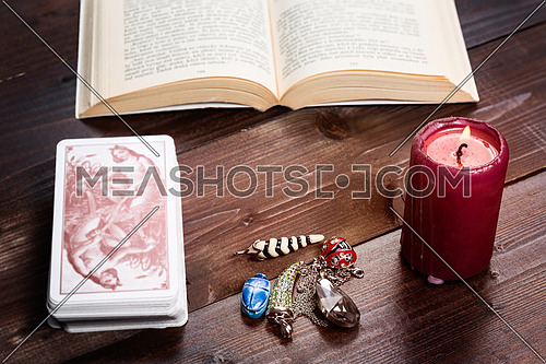 Composition of esoteric objects,candle,cards and book used for healing and fortune-telling.