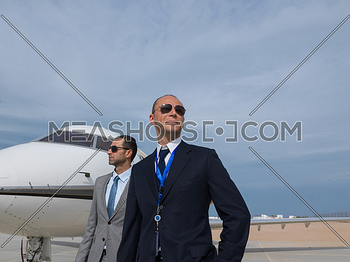 portrait of middle eastern pilot and a successful businessman in front of private airplane