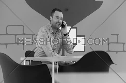 Senior businessman with beard using cell phone at  stratup office