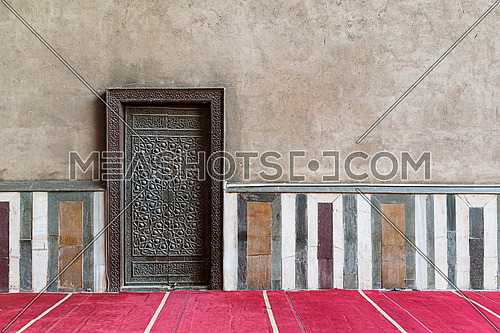 Old wall including a historic decorated bronzed door in an old mosque, Cairo, Egypt