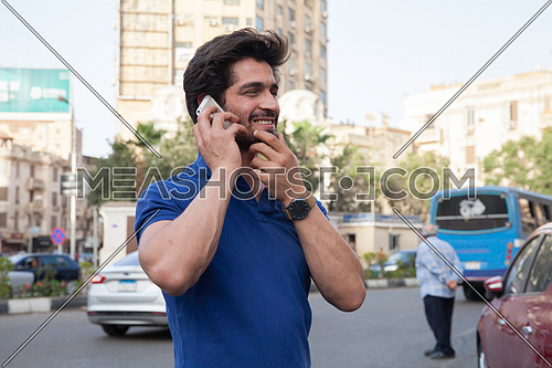A young man in the street talking on his mobile