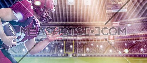 American football Player running with the ball isolated on big modern stadium field with lights and flares