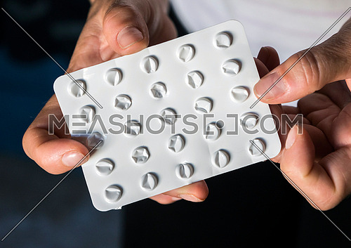 Woman holds blister pack of pills empty in their hands, conceptual image
