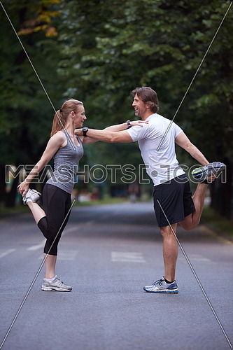jogging couple warming up and stretching before running