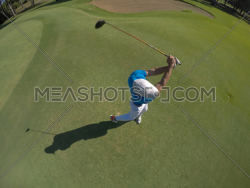 top view of golf player hitting shot with club on course at beautiful morning