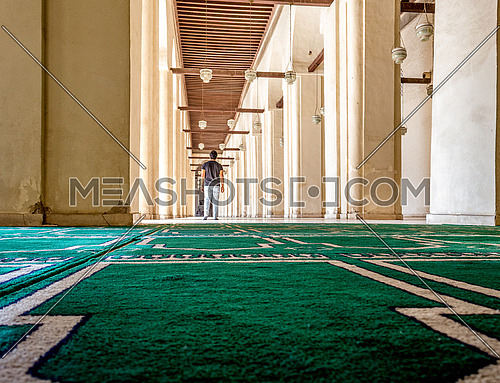 ElHakem Mosque with a man standing on the praying carpet