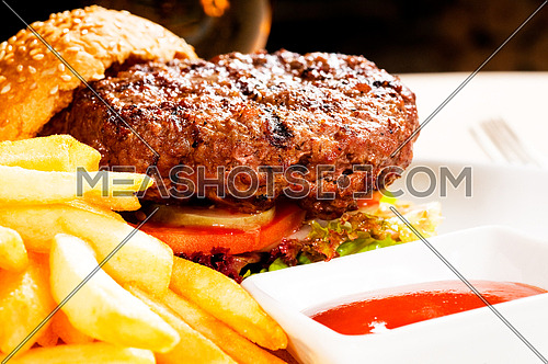 fresh classic american hamburger sandwich with french fries and ketchup sauce on side