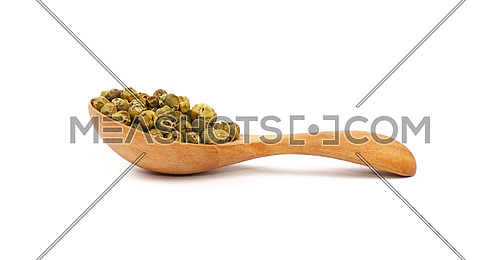 Close up one wooden scoop spoon full of green pepper peppercorns isolated on white background, low angle side view