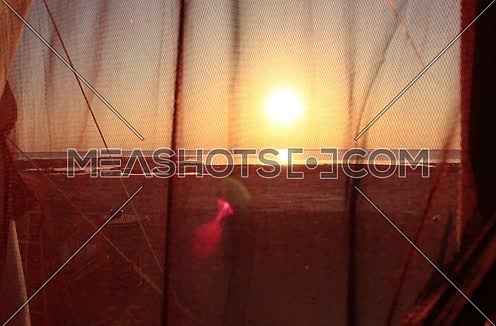 Closeup shot inside tent unreveal the tent cover door towards the sun ans shore at sunset at Wadi Lahmi - 5D