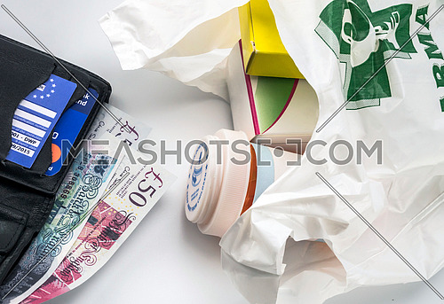 European health insurance card in a wallet along with several pounds sterling and medicines in a bag, concept of medical increase in the crisis of the brexit, conceptual image, horizontal composition