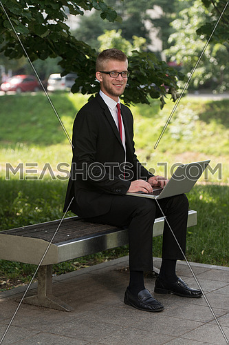 Happy Business Man Using Tablet Pc Outside On A Park Bench