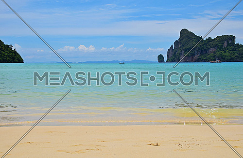 Paradise tropical sunny sand sea beach with sky blue water and forest rock