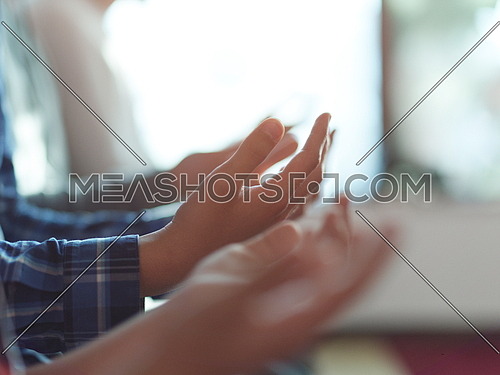 group of muslim people praying namaz  in mosque together closeup on hands