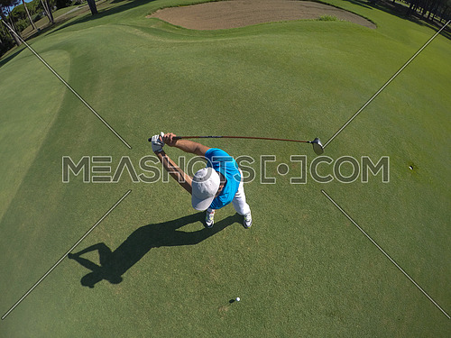 top view of golf player hitting shot with club on course at beautiful morning