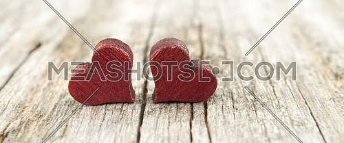 Two wooden hearts on the cracked rustic wooden table