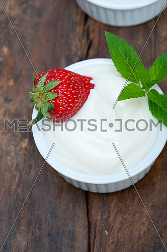 organic Greek yogurt and strawberry on a rustic wood table
