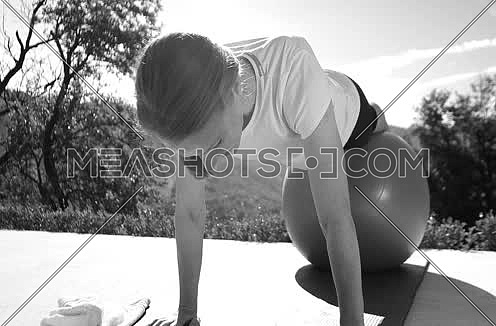 Woman practicing Yoga in front of luxary mansion