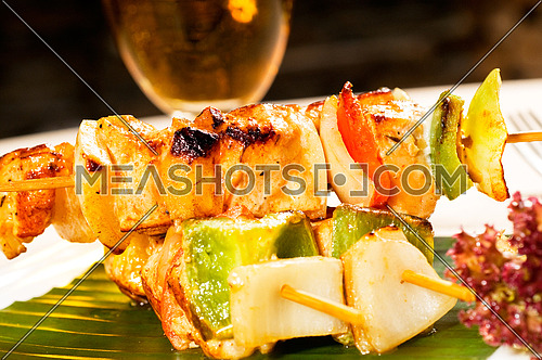 fresh chicken and vegetables skewers on a palm leaf thai style