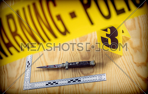 scene of crime, razor spotted with blood, rule of ballistic measurement, conceptual image, horizontal composition