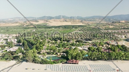 Aerial view of beautiful sea and beach with parasol at sunny day, seascape and hill mountain on backgrond, Simeri Mare, Calabria, Southern Italy