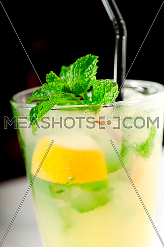 mojito caipirina cocktail with fresh mint leaves ,yerba-buena, with lime and black straw