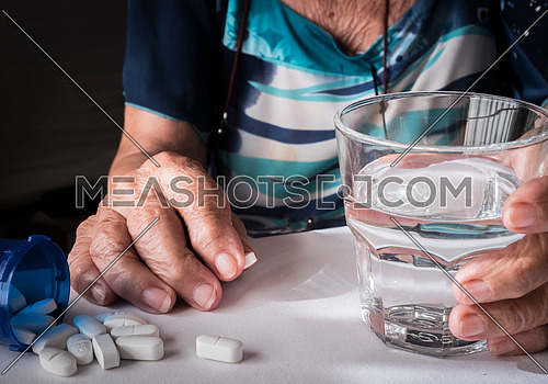 Oldster taking daily medication dose at home, Andalusia, Spain