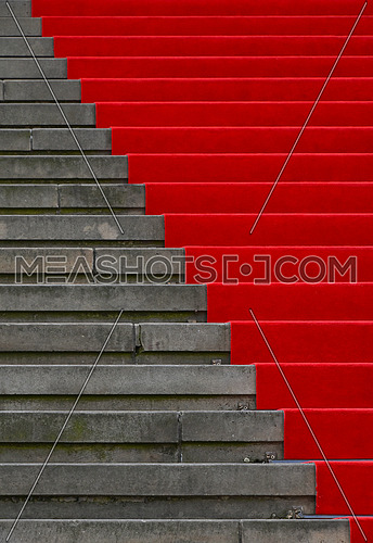 Close up red carpet over grey concrete stairs perspective ascending, low angle view