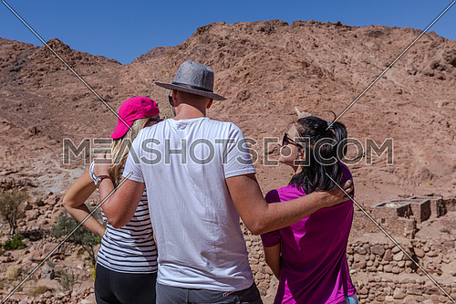 Group of tourists from behind exploring Sinai Mountain for wadi Freij at day.