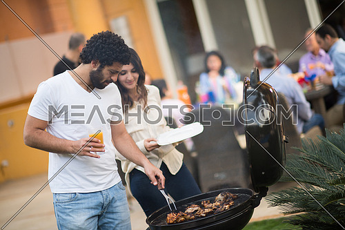 happy middle east family enjoying the beautiful summer afternoon with a barbecue in the garden