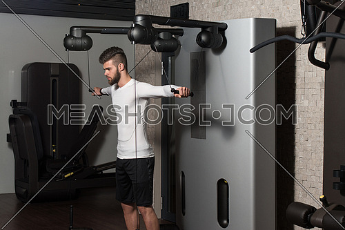 Handsome Man Is Working On His Shoulders With Cable Crossover In A Modern Gym