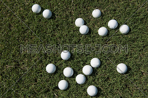 top view flat lay of golf balls with driver on grass background