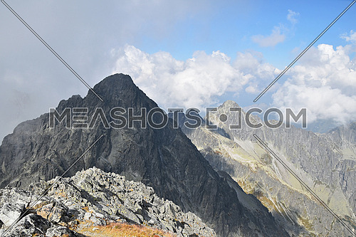 Landscape with dark rocky mountain ridge silhouette in foggy clouds, High Tatra mountains