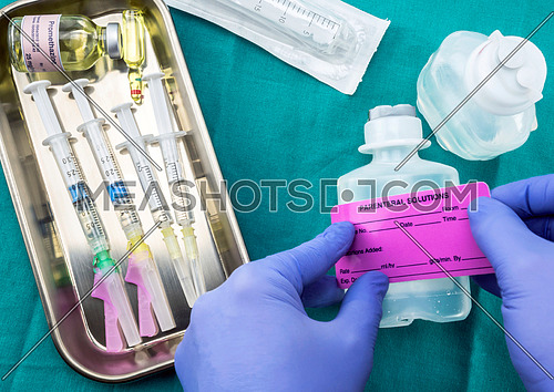 Nurse preparing hospital medication, solution sticker parenteral medicine, conceptual image, horizontal composition