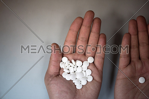 white pills in his hands