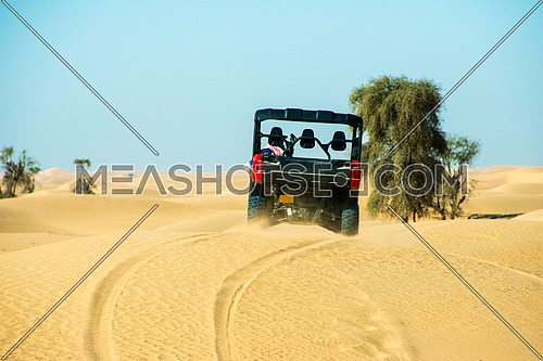 An ATV quad bike dune bashing in the desert