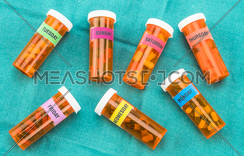 Capsules bottles with indication of days of the week, palliative care in hospital, conceptual image, horizontal composition