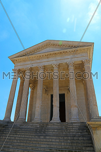 Front view of Maison Carree (square house), ancient building in Nimes, France, one of the best preserved antique Roman temple facades, low angle