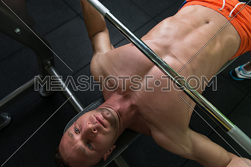 Close-Up Of A Young Man In Gym Exercising Chest On The Bench Press